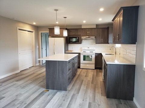 A modern kitchen with a large island and stainless steel appliances.